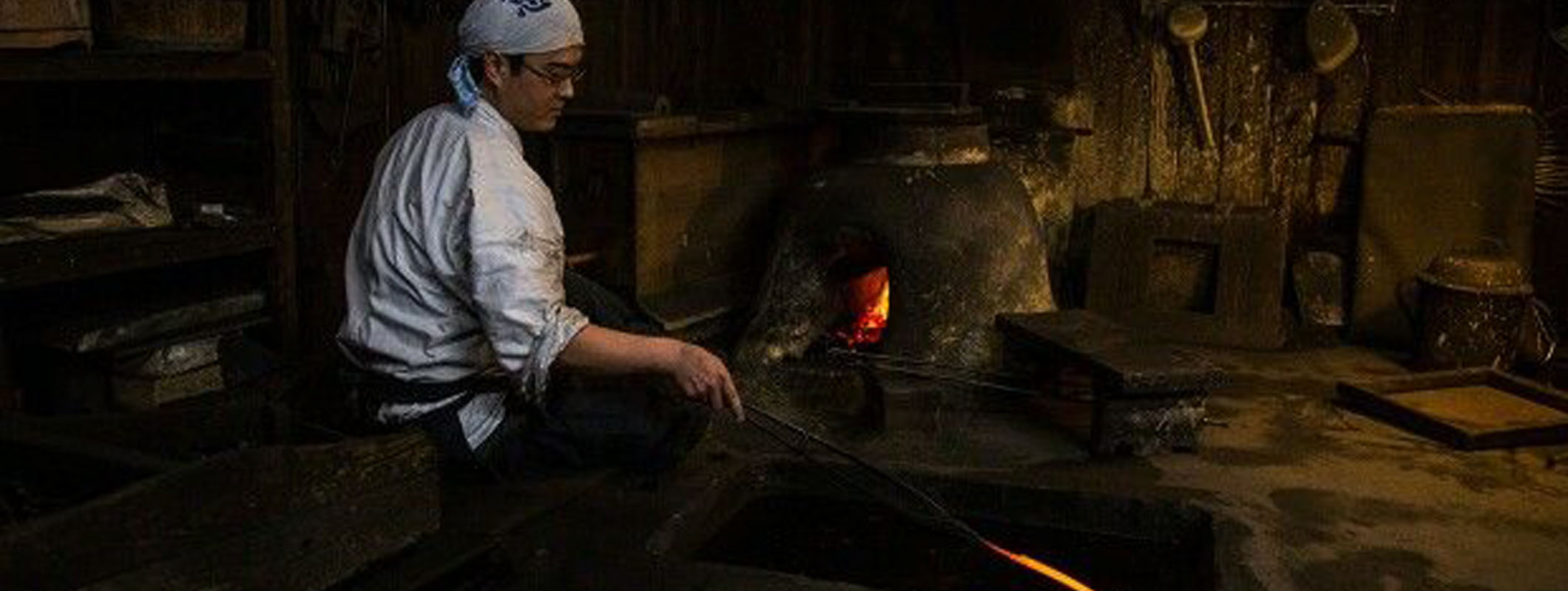 Japanese swordsmith forging a traditional sword using classical hammering techniques