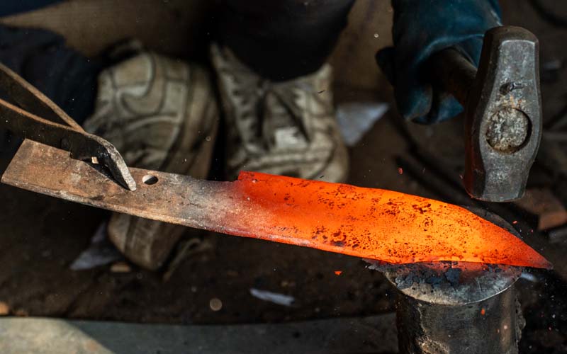Shaping and grinding a hand-forged blade at Everest Forge — establishing edge geometry, bevel and fuller on a sword, kukri or machete in Kathmandu, Nepal