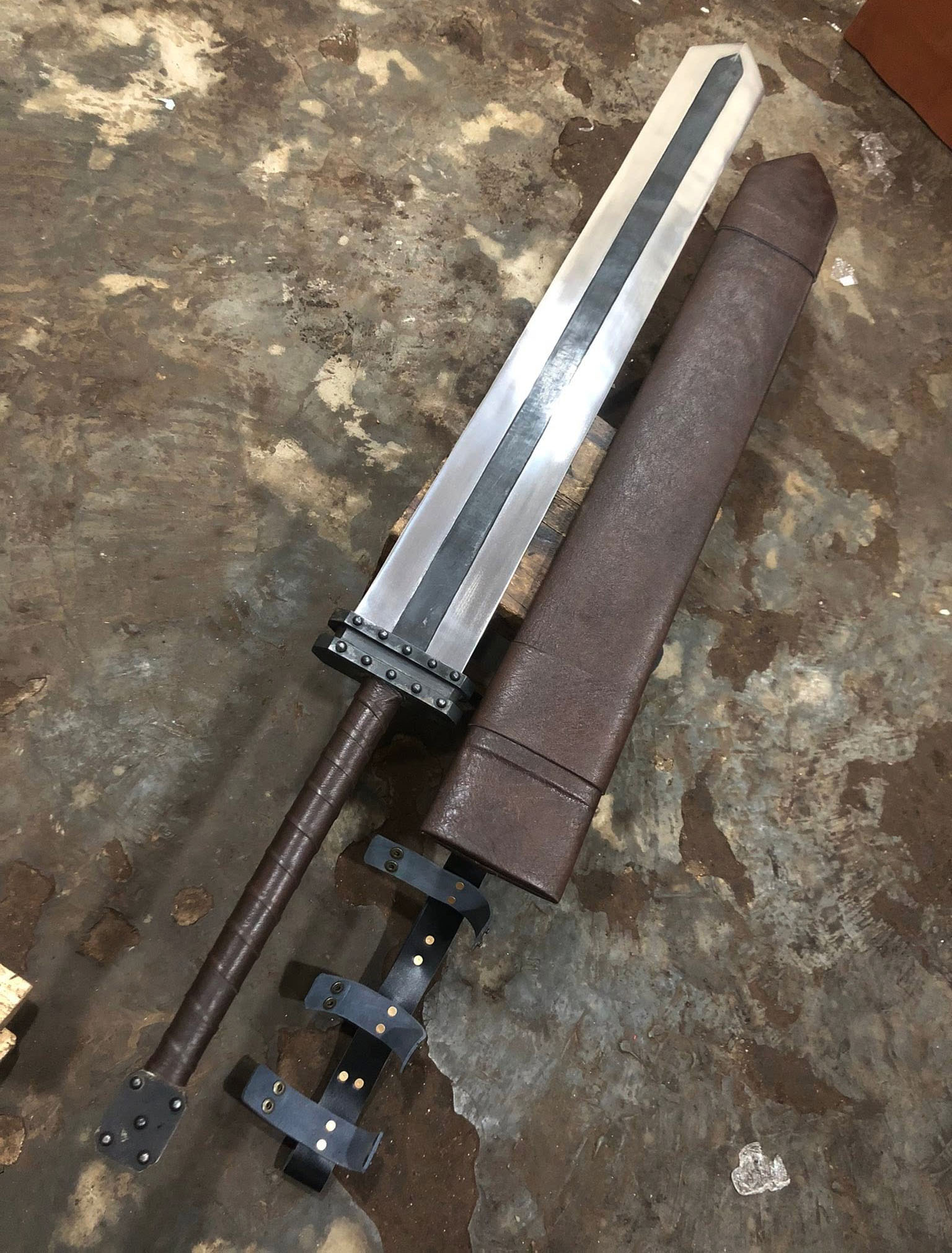 Hand-forged Golden Age Guts sword from the same forge with leather wrap, riveted fittings and leather scabbard