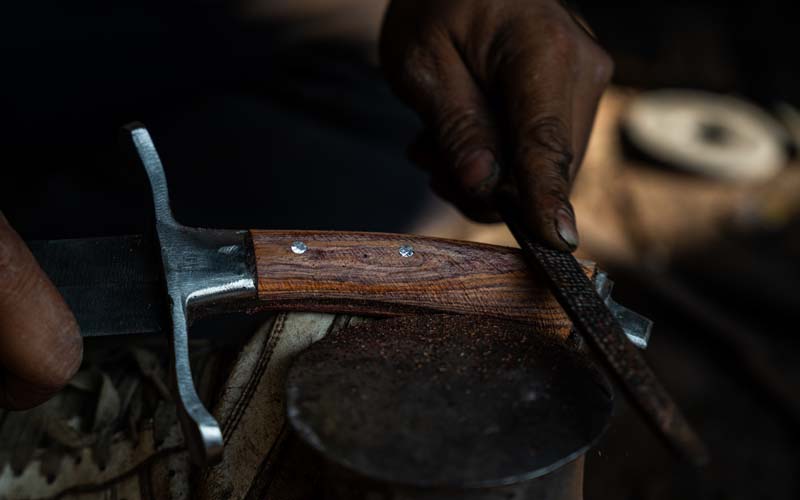 Handle fitting and finishing at Everest Forge — securing rosewood, horn and bone handles to hand-forged blades using full tang construction in Kathmandu, Nepal